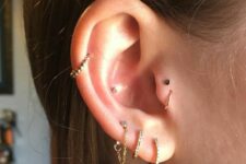 minimal ear styling with a triple lobe, conch, mid-helix, double tragus piercing done with hoops and studs is lovely