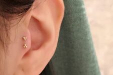 minimalist ear styling done with a double tragus piercind accented gold tripod studs is great