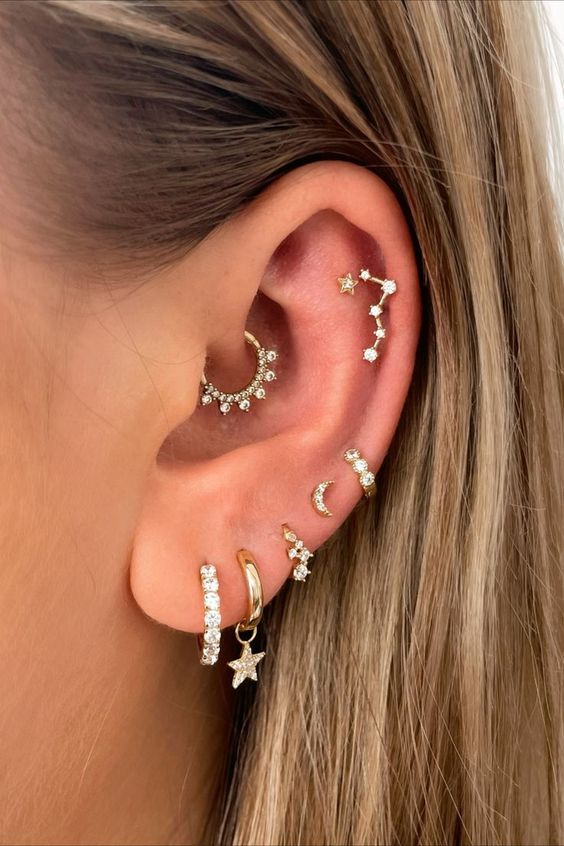 refined ear styling with stacked lobe, high lobe, helix, flat and daith piercings plus hoops and studs of gold