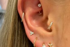 refined ear styling with stacked lobe including high lobe piercings, a helix, rook and tragus one, with gold hoops and studs