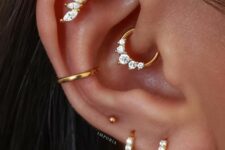 stacked and high lobe, daith, conch and flat piercings done with hoops and a stud look very chic and bold