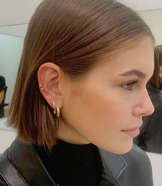 stacked lobe and stacked high lobe piercings done with statement hoops and studs look very chic