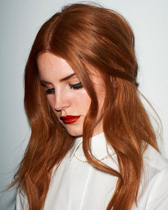 Lana Del Rey wearing fantastic copper red locks with central parting and a touch of shine looks wow