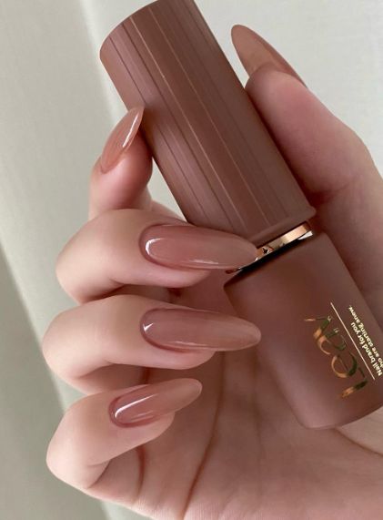 a beautiful brownish nude shade on long almond-shaped nails brings a sophisticated feel