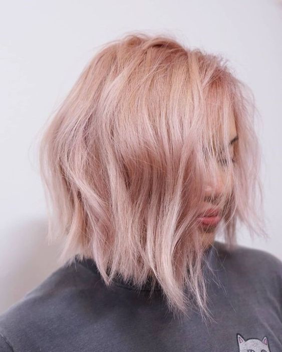 a pastel pink long bob with textural waves and side parting is a modern and chic idea for rocking right now