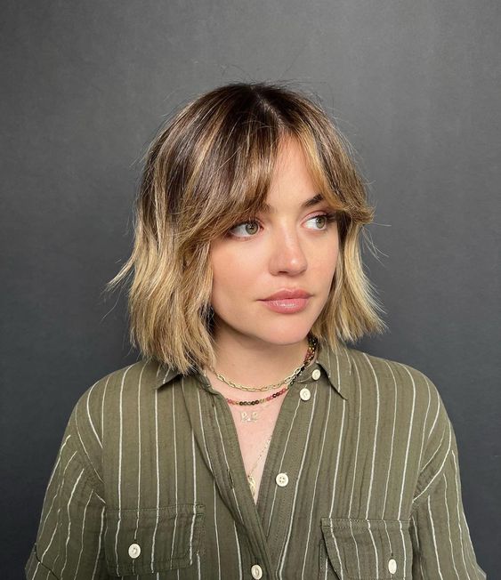 a shaggy bob with curtains bangs, central parting and a blonde balayage is a classy idea to try