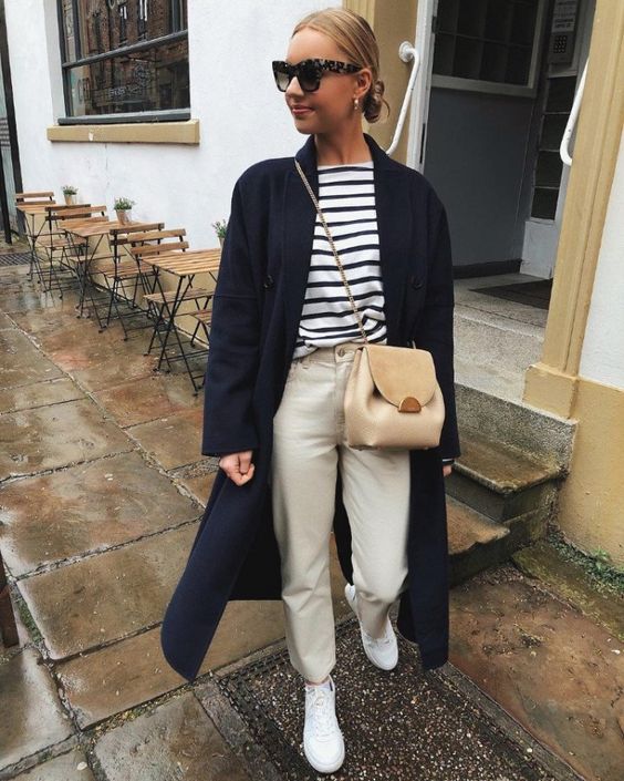a Breton stripe top, neutral jeans, white sneakers, a navy trench and a tan bag are amazing for spring
