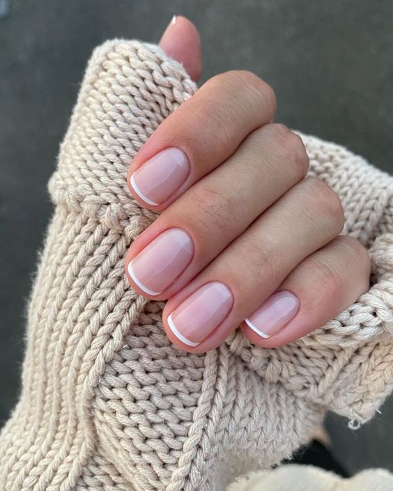 a classy French manicure with nude nails and small white tips is a more modern version of this manicure