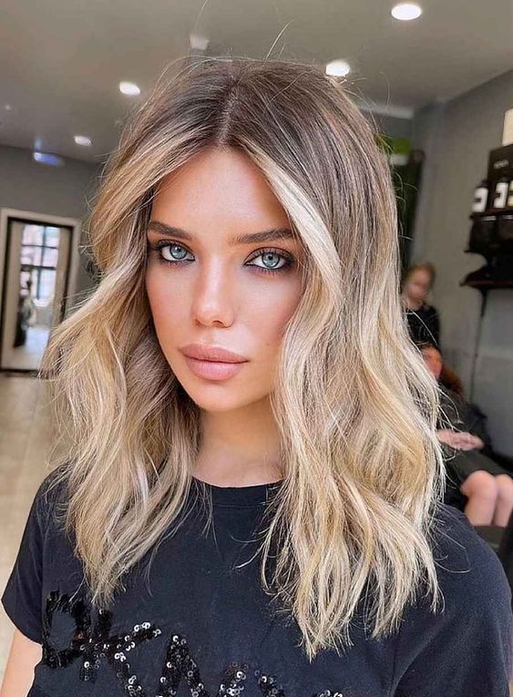 beautiful expensive blonde hair with a darker root and balayage, with soft and natural shades looks amazing