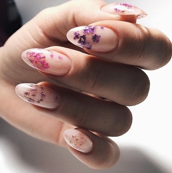 a chic blush manicure with colorful pressed blooms of purple and pink shades is a beautiful and girlish idea for spring and summer
