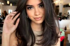 28 a beautiful and voluminous dark chestnut haircut with layers and side bangs is a very chic and bold idea