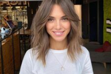 32 a medium length chestnut shaggy haircut with curtains bangs and a bit of texture is super cool and chic