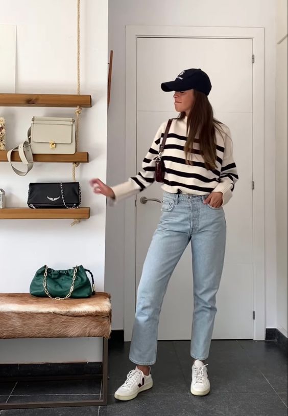 a Breton stripe jumper, bleached blue jeans, white sneakers, a brown bag and a black cap are a lovely everyday look