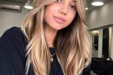 35 long hair with a darker root and blonde balayage and curtain bangs, with waves and volume is cool