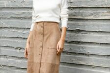 An outfit with a white turtleneck and a beige suede button front midi skirt