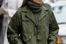 Kate Moss wearing a grey turtleneck sweater and a green utility jacket looks amazing