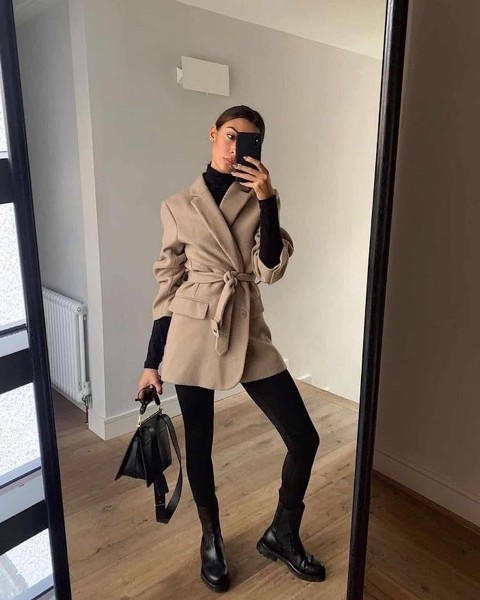 With beige belted coat, black leather bag and black leather mid calf flat boots