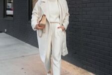 With beige framed sunglasses, beige leather chain strap bag, white lace up flat shoes and white midi coat