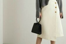 With silver earrings, black leather mini bag and dark blue leather high heeled shoes