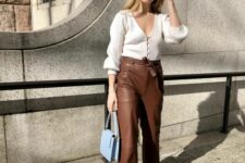 a beautiful and feminine look with a white ribbed cardigan tucked into brown leather pants, white shoes and a blue bag