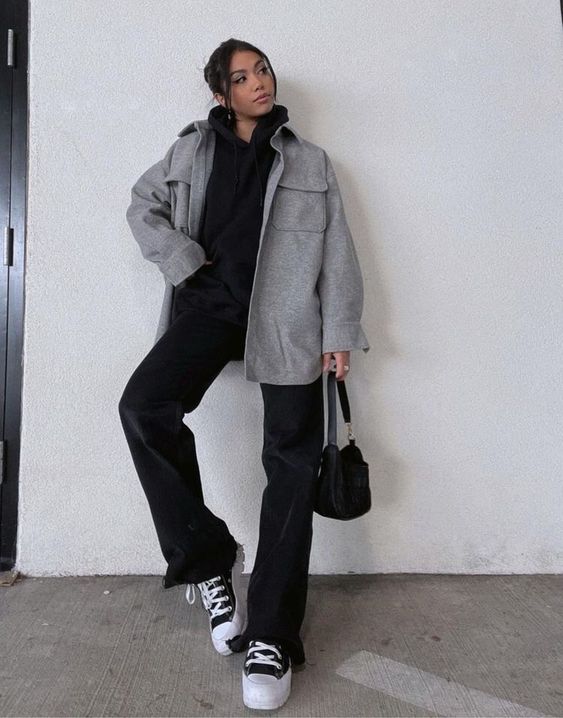 a black hoodie, black flare pants, black sneakers and a bag, a grey shirt jacket are a cool monochromatic look for winter to spring time