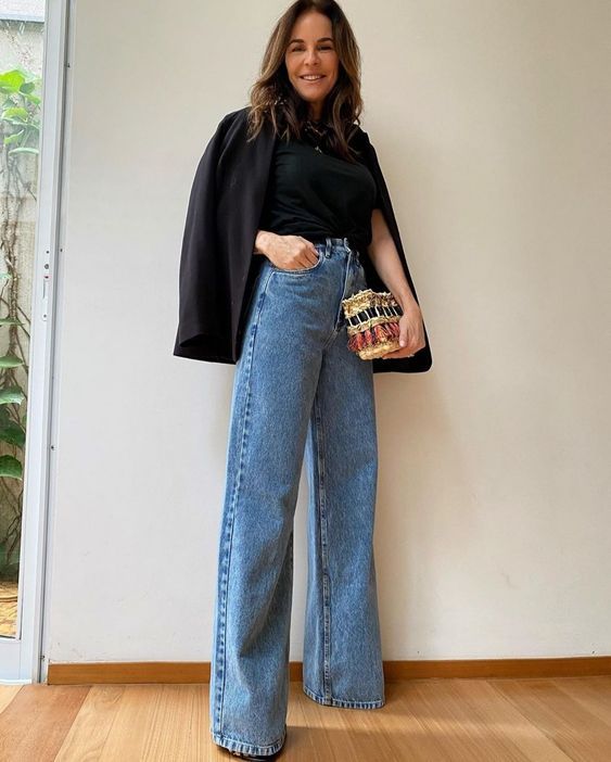 a black t-shirt, a black blazer, blue wide leg jeans, a woven bag with tassels are a lovely look for spring