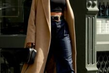 a black turtleneck crop top, navy striped straight leg pants, white trainers, a beige maxi coat and a black bag