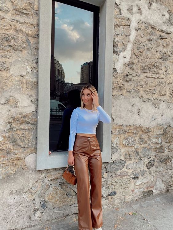 a blue long sleeve crop top, brown leather pants, a brown suede bag for a romantic spring look