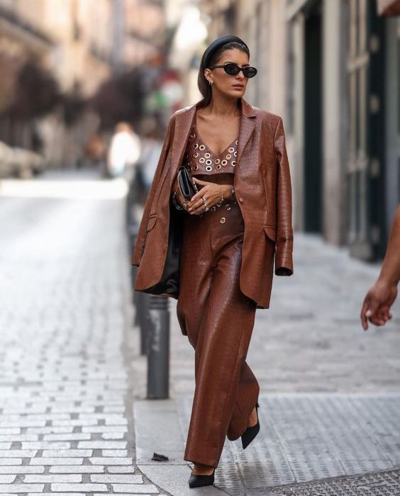 a brown crocodile leather blazer and matching pants, a polka dot crop top, black shoes and a clutch for a chic and bold look