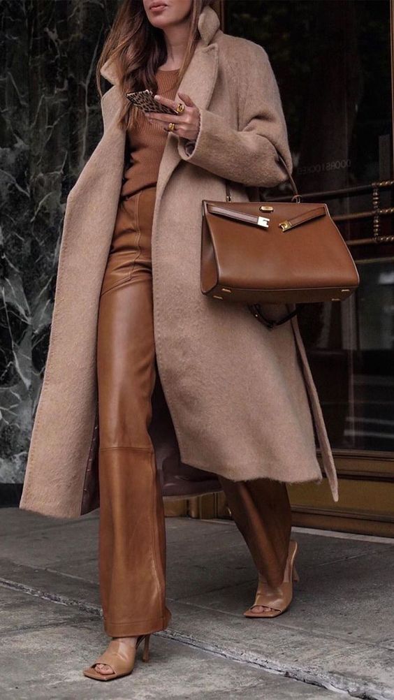 a brown top, brown leather pants, tan leather shoes, a tan coat and a brown bag for a super refined winter to spring look