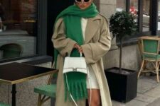 a creamy sweater dress, a neutral maxi trench, black boots, an oversized green scarf and a neutral bag