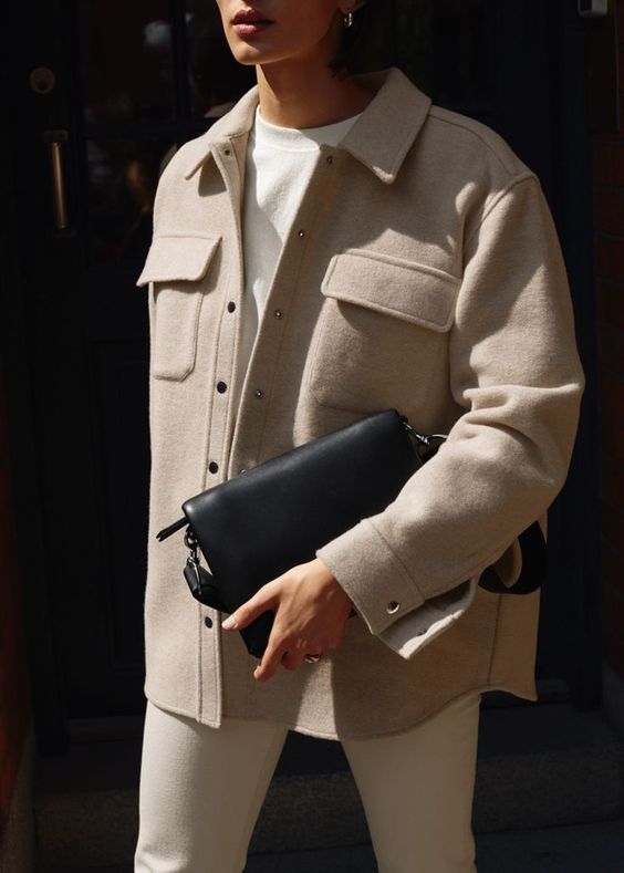a creamy sweatshirt, creamy jeans, a tan shirt jacket and a black bag are a lovely combo for the transitional time