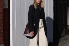 a fall work look with a black turtleneck and an oversized blazer, white wideleg jeans, black shoes and a woven bag