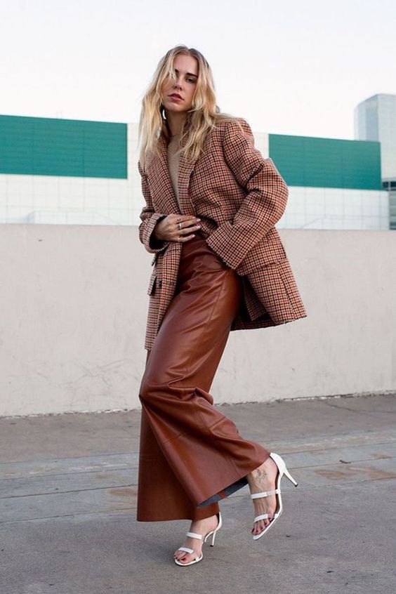a greige t-shirt, brown leather pants, an oversized plaid blazer and white strappy shoes for an elegant office outfit