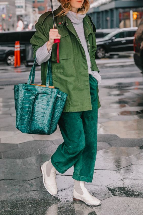 a grey sweater, emerald pants, a green utility jacket, white Chelsea boots and an emerald tote
