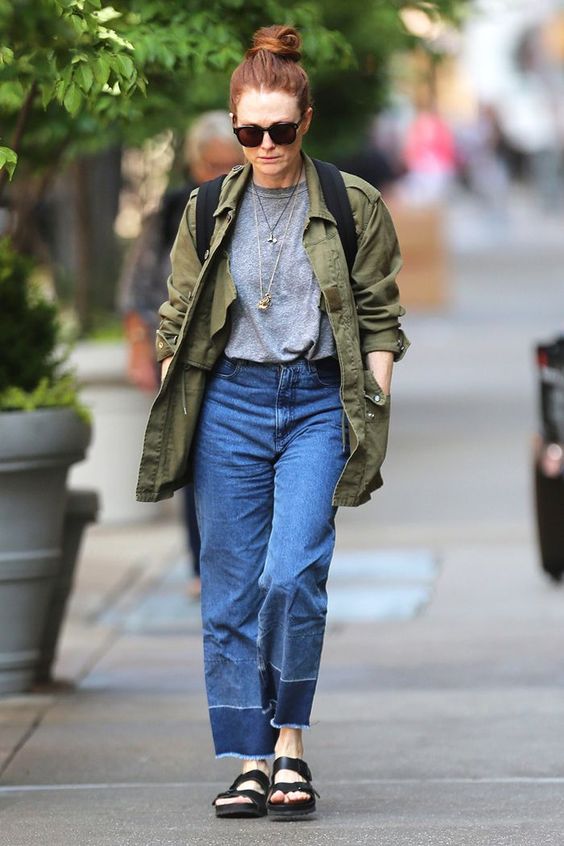 a grey t-shirt, blue straight leg jeans, black platform sandals, a green utility jacket and a backpack