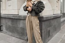 a neutral sweater, tan pleated pants, a black cropped leather jacket, black boots for the transitional time