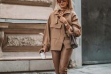 a total beige look with a shirt jacket, leather pants, brown boots and a taupe bag is all about elegance and modern chic