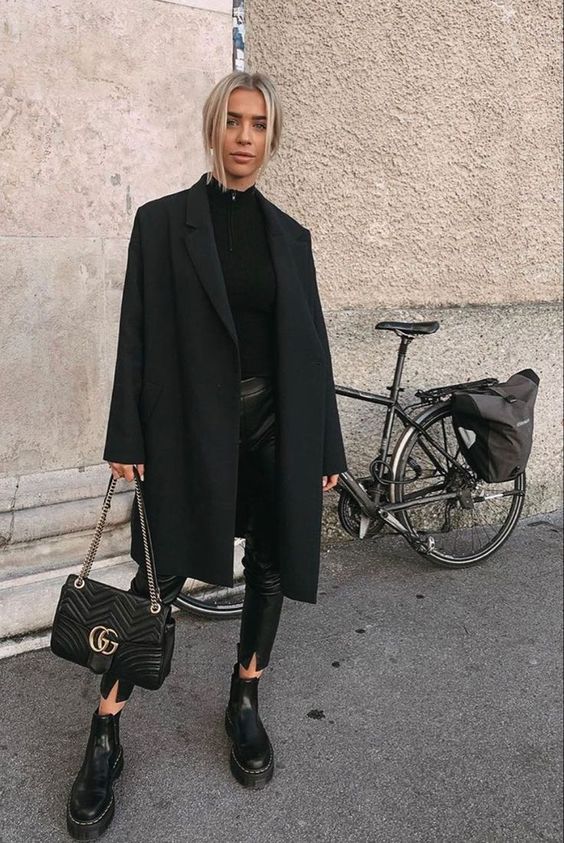 a total black look with a zip sweater, cropped leather pants, combat boots, a midi coat and a bag is lovely