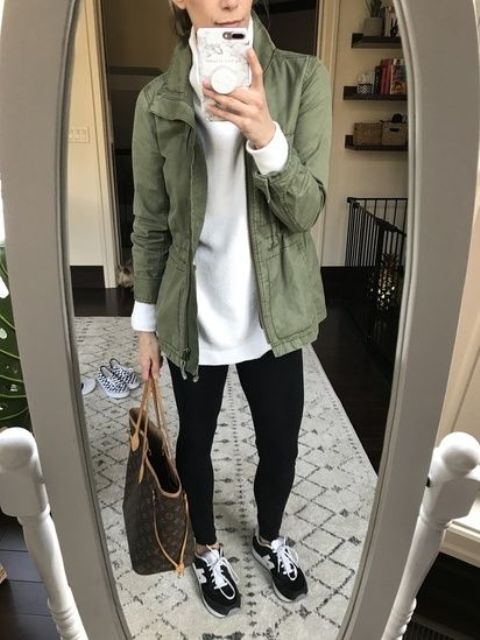 a white turtleneck, black leggings, black trainers, a green utility jacket, a large printed tote are a lovely look