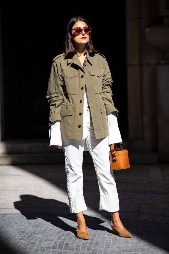 an oversized white shirt and white jeans, brown shoes, an amber bucket bag and a utility jacket