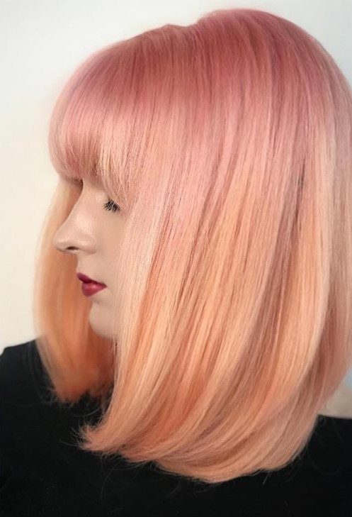 this soft-looking bob haircut looks like a peach cloud, with the top layer a cooler pink tone and a subtle ombre