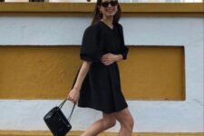 02 a black A-line over the knee dress with puff sleeves, black high top sneakers and a small black bag for a spring to summer day