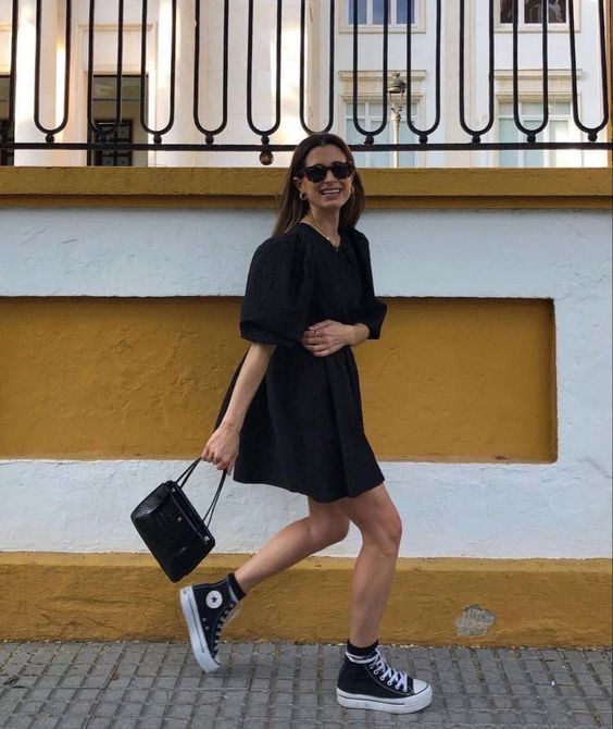 a black A-line over the knee dress with puff sleeves, black high top sneakers and a small black bag for a spring to summer day