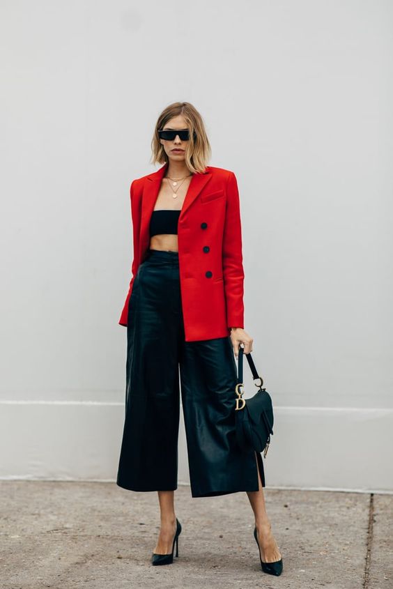 a black bandeau top, black leather culottes, black heels, a saddle bag and a bold red blazer