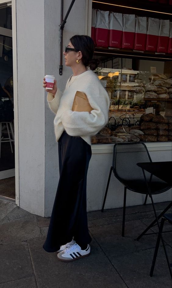 a black slip maxi skirt, a neutral jumper, white Adidas sneakers are a comfy and cozy spring outfit