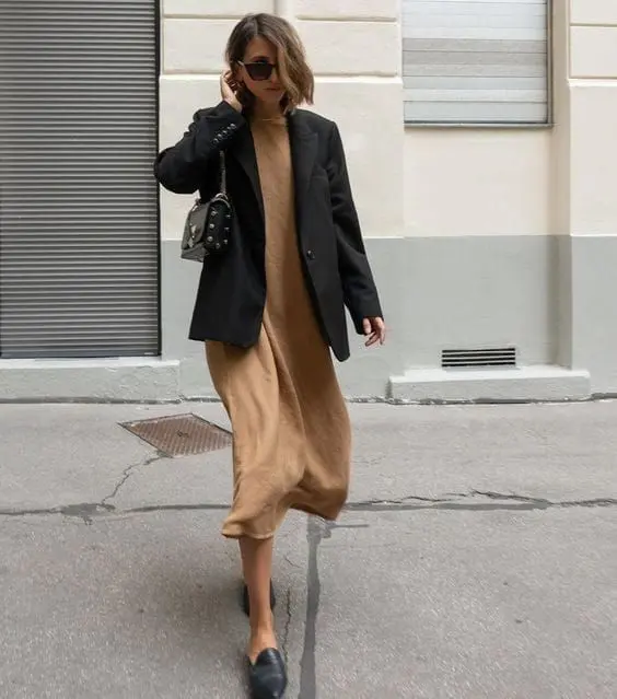 a beige midi dress, an oversized black blazer, black slippers and a studded bag for an elegant spring work look