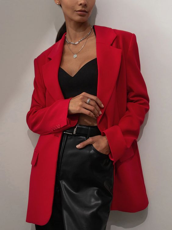 a black sweetheart top, black leather pants, a red oversized blazer, layered necklaces are a super sexy combo