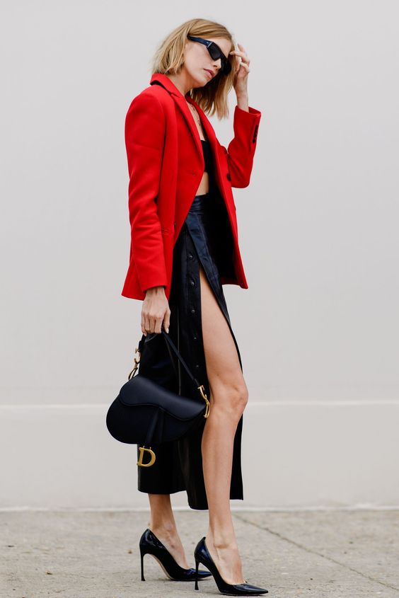 a black crop top, a black midi skirt with a slit, black heels and a saddle bag, a red blazer just scream sexy