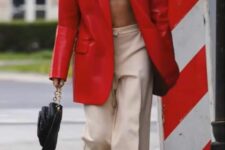 07 a bold look with a woven crop top, tan pants, a black bag with chain, an oversized red leather blazer